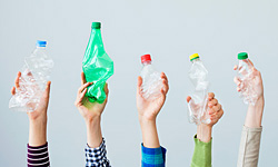 A photo of hands holding empty plastic bottles